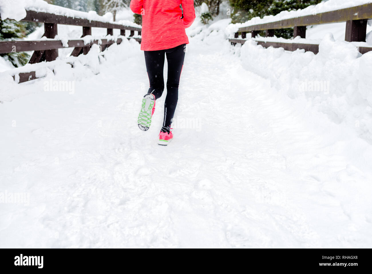 Junge Frau läuft auf Schnee im Winter Berge tragen warme Kleidung Handschuhe im Schnee Wetter. Sport, Fitness Inspiration und Motivation. Gerne jugendlich nicht Stockfoto