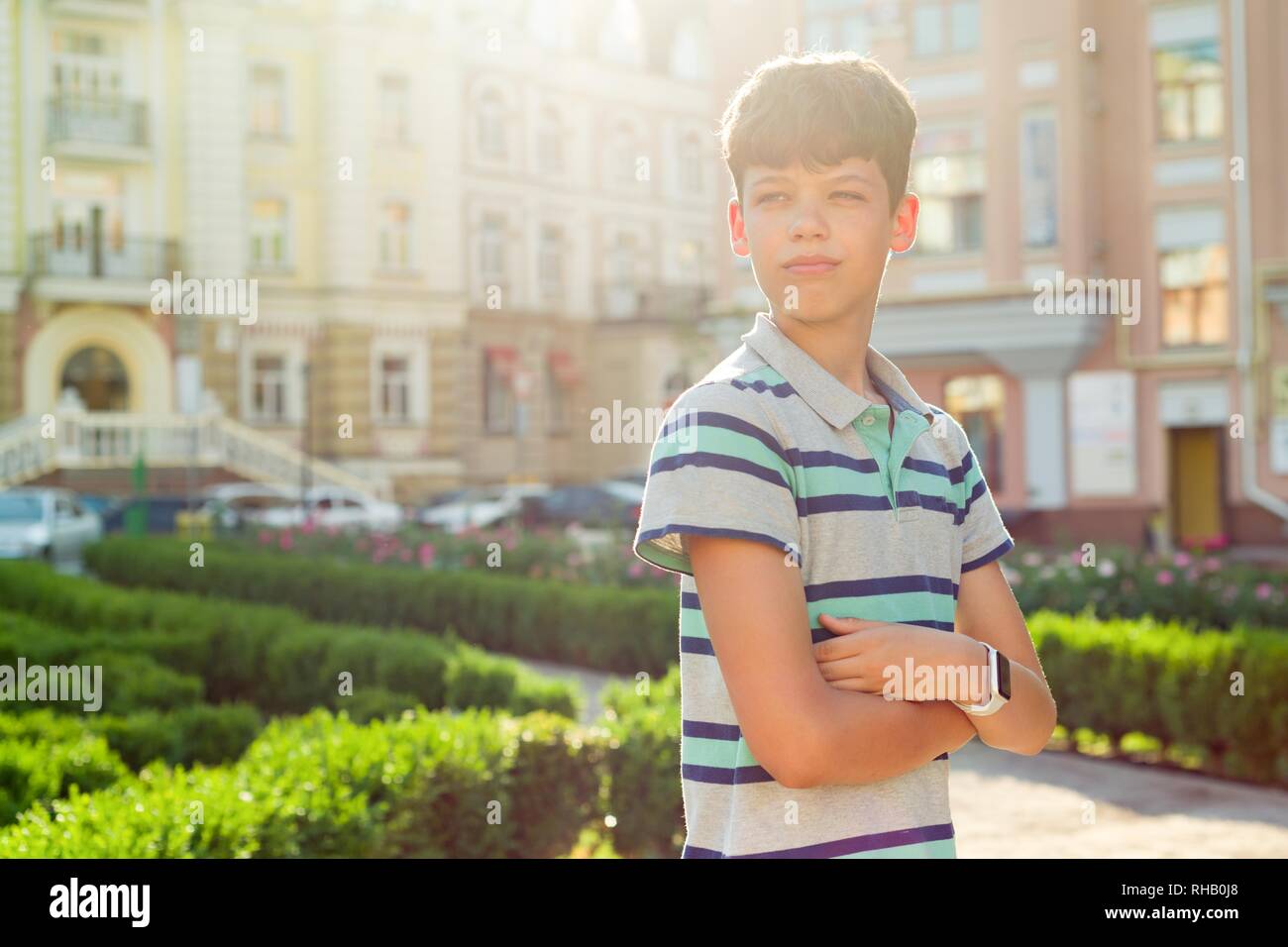 Outdoor Portrait von Jugendlicher 13, 14 Jahre alt, Junge mit verschränkten Armen, im städtischen Hintergrund. Stockfoto
