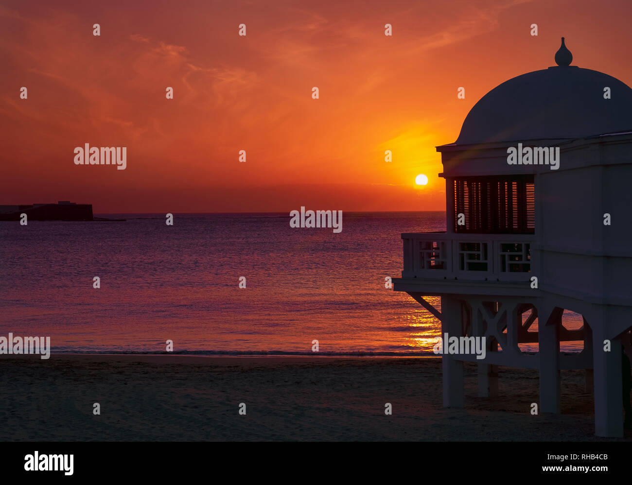 Sonnenuntergang über dem berühmten Pier des Strandhafens La Caleta. Cadiz, Andalusien Stockfoto