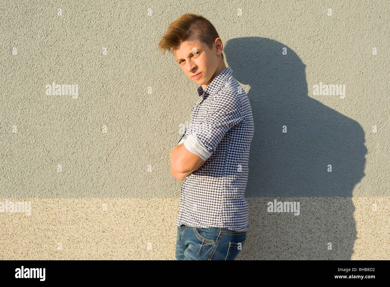 Outdoor Portrait von Teenage boy 14, 15 Jahre alt. Graue wand hintergrund, kopieren Raum Stockfoto