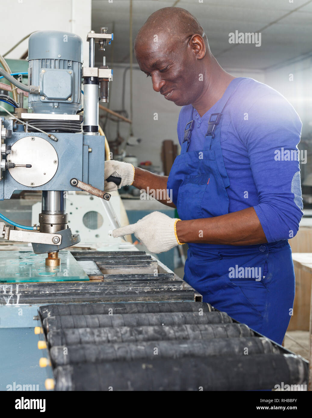 Schwere Afrikanische amerikanische Handwerker arbeiten an Glas-bohrmaschine  Tabelle in der Werkstatt Stockfotografie - Alamy