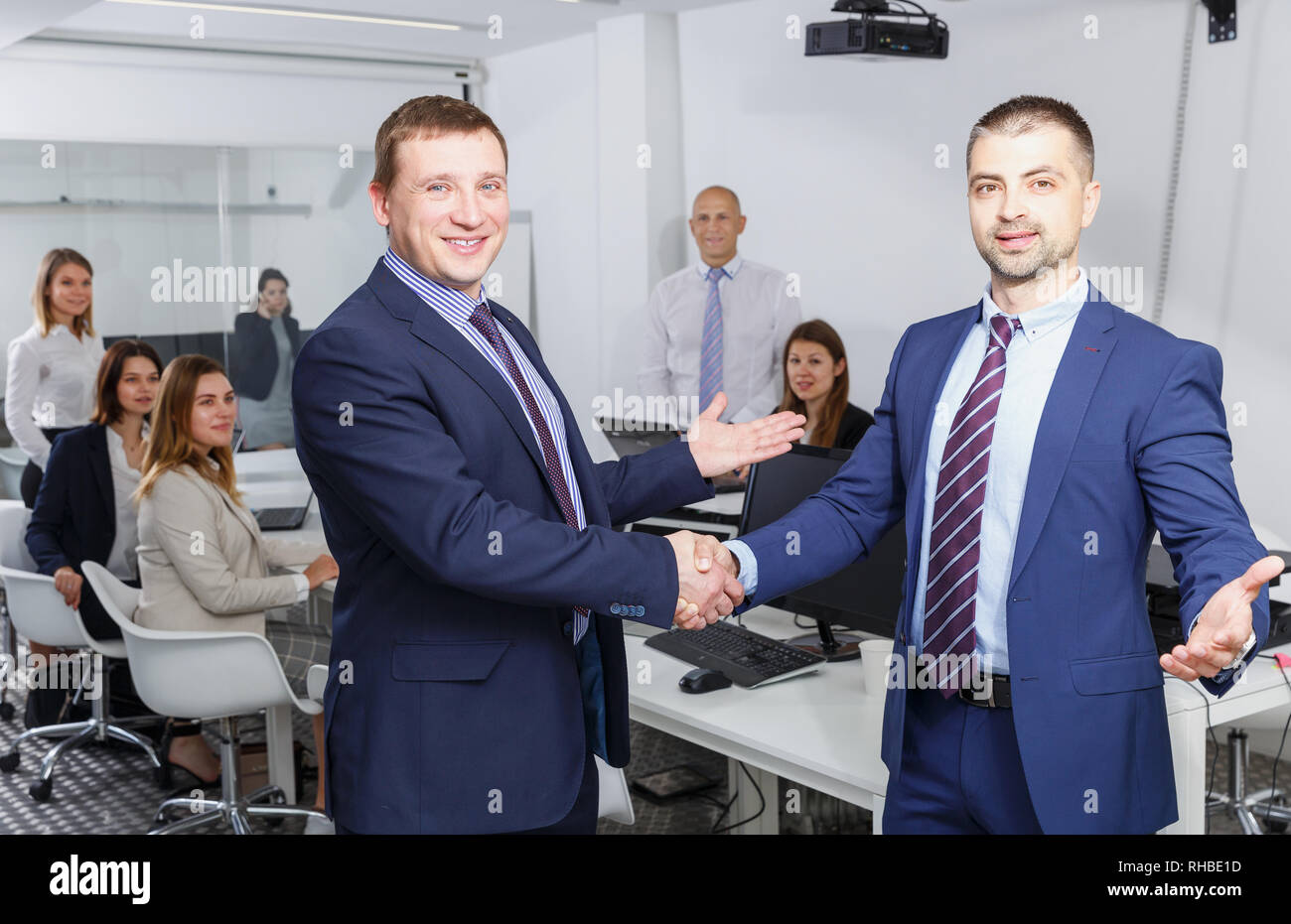 Junge Unternehmer zufrieden die Hände schütteln, während Sie schlichten Treffen, die Vereinbarung Stockfoto