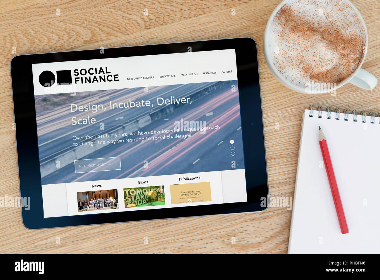 Die Social Finance website Funktionen auf einem iPad Tablet Gerät, das auf einem Tisch liegt neben einem Notizblock (nur redaktionelle Nutzung). Stockfoto