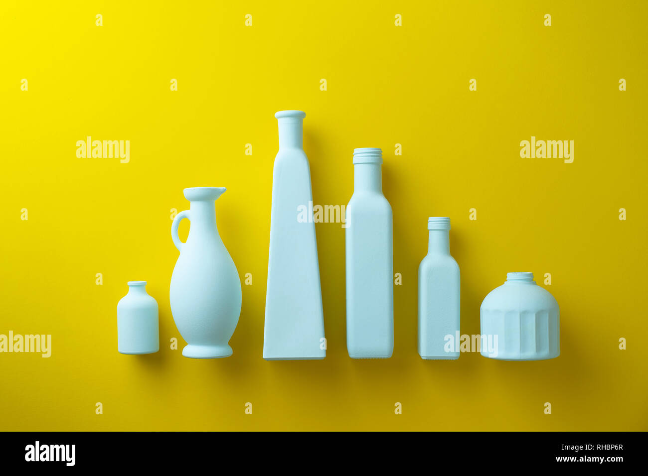 Bunt bemalten Glas Flaschen in einer Reihe über gelben Hintergrund organisiert Stockfoto