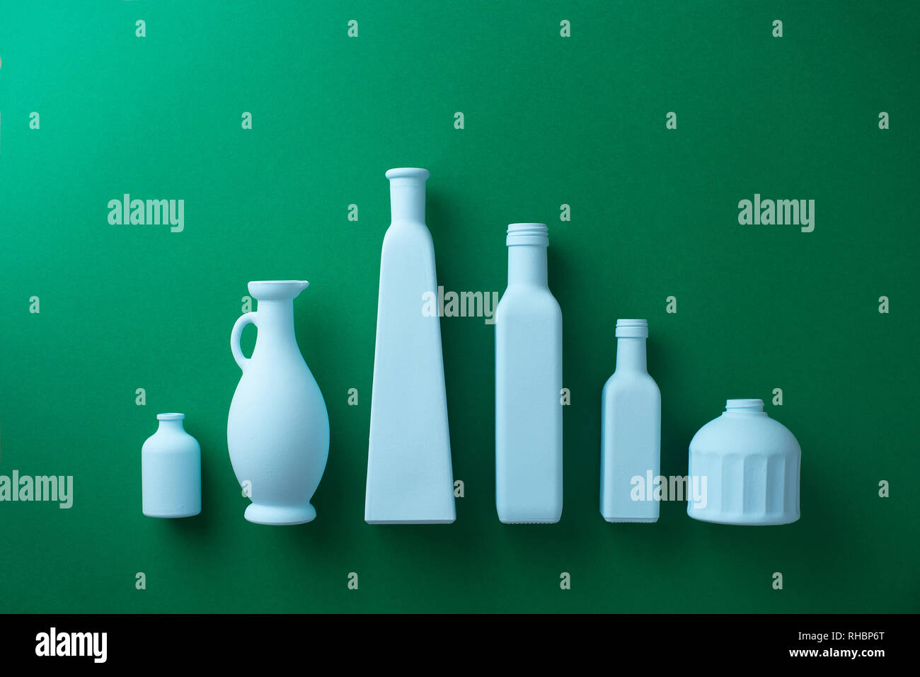 Bunt bemalten Glas Flaschen in einer Reihe über grünen Hintergrund organisiert Stockfoto