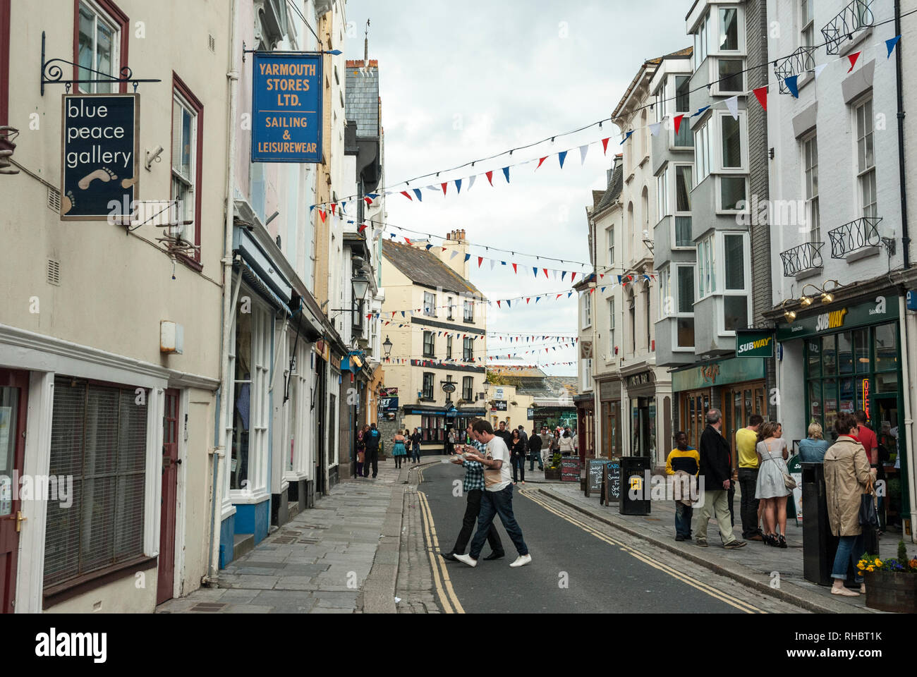 Blick entlang der belebten und beliebten, historischen Southside Straße, Barbican, Plymouth, mit Personen, die farbenfrohen Läden und Pubs, mit bunting Overhead. Stockfoto