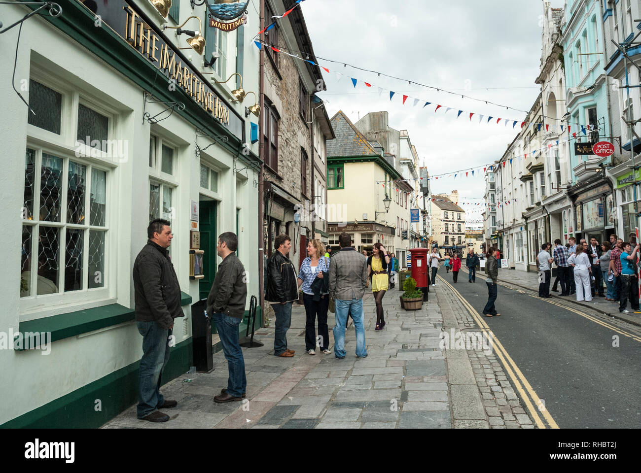 Blick entlang der belebten und beliebten, historischen Southside Straße, Barbican, Plymouth, mit Personen, die farbenfrohen Läden und Pubs, mit bunting Overhead. Stockfoto