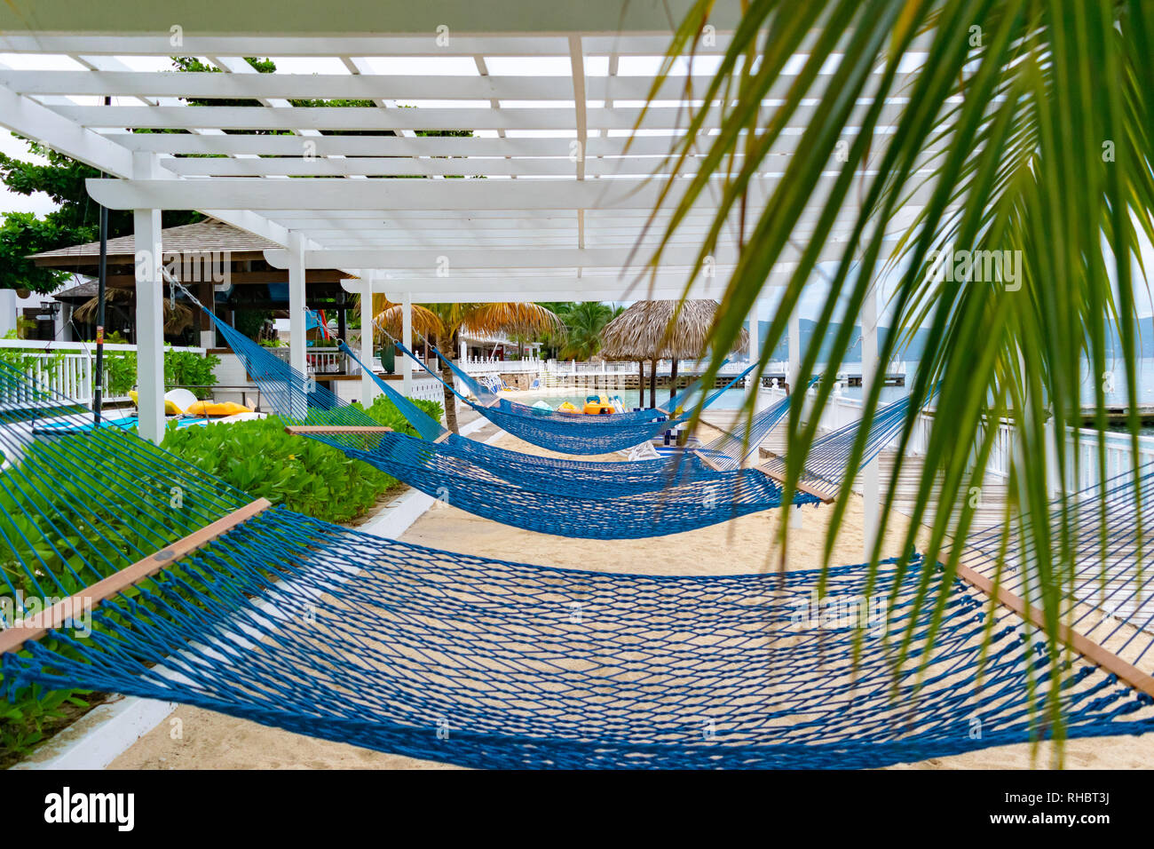 Leere blaue Hängematten auf weißen Sand tropical beach resort in der Karibik Stockfoto