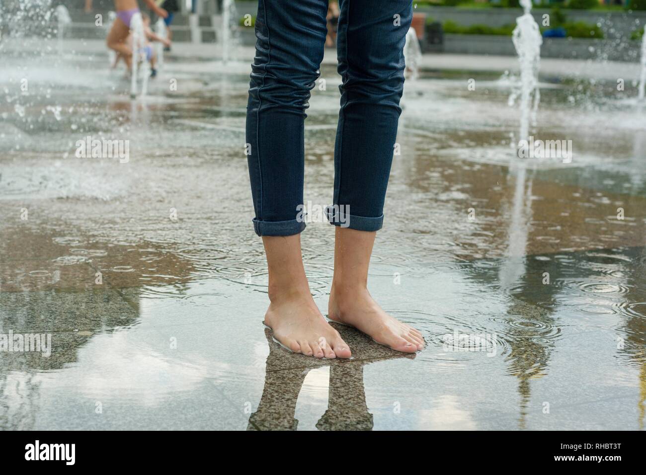 Symbol der Sommer Brunnen, Coolness. Beine der Mädchen in nassen Kleidern in Brunnen Stockfoto