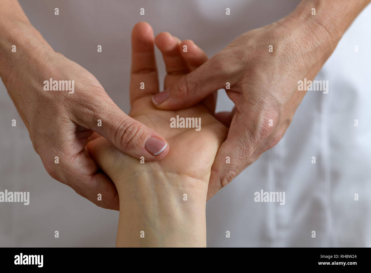 Nahaufnahme Foto einer Hand einer 30-35 Jahre alten Kaukasische liegende Frau auf einem Massagetisch und immer Hand und Fuß Massage und Akupressur behandeln Stockfoto