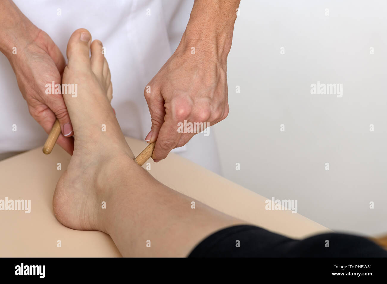 Nahaufnahme Foto von einem Fuß einer 30-35 Jahre alten Kaukasische liegende Frau auf einem Massagetisch und immer Hand und Fuß Massage und Akupressur behandeln Stockfoto