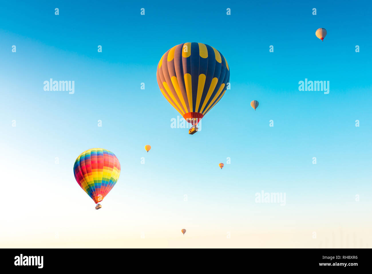 Bunte Heißluftballons auf blauen Himmel Hintergrund isoliert. Bunten Heißluftballon über an Feenkamine in Nevsehir, Göreme in Kappadokien Türke fliegen Stockfoto