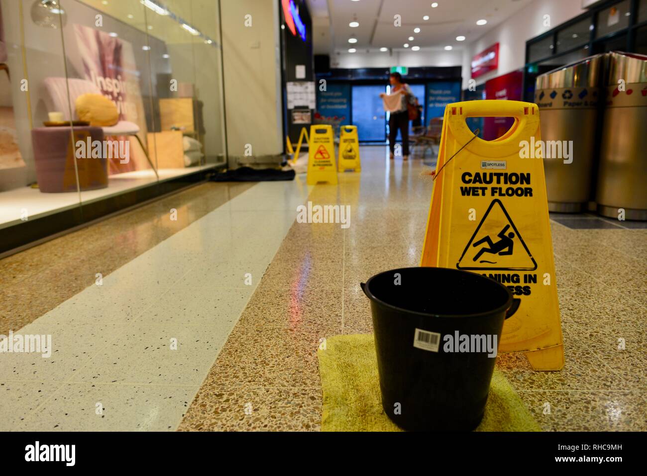 Vorsicht nasser Boden anmelden und einen Eimer, in Stockland Shopping Center als Townsville Hochwasser, Überschwemmung weiter verschlechtert, wie die sintflut fortgesetzt und mehr Wasser aus dem prallen Ross River dam freigegeben das Scheitern der Staumauer zu verhindern. Townsville, Queensland, Australien Stockfoto