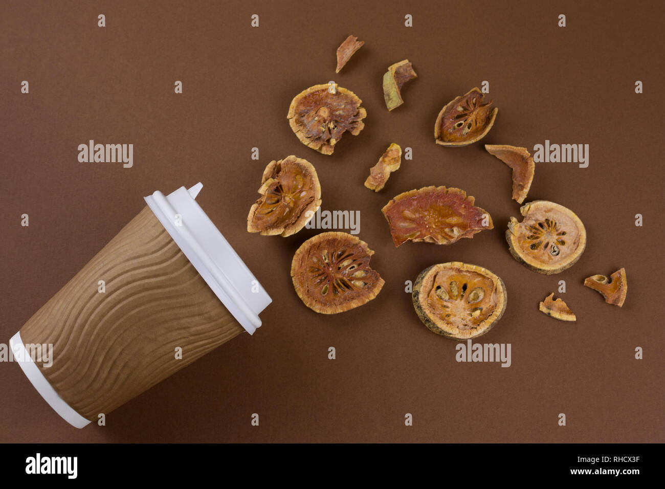 Ansicht von oben matum nehmen Sie Kaffee und getrockneten bael Früchte flach auf braunem Hintergrund legen Stockfoto