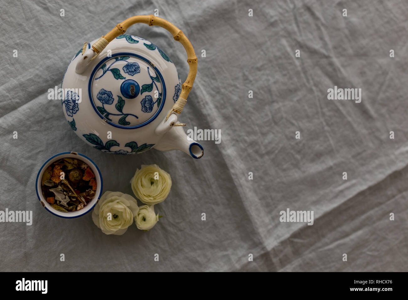 Obere Ansicht geschossen von Kräutertee serviert in whtie und blau Keramik Tasse und Kännchen auf grau Leinen Tischdecke. Horizontale geschossen und negativen Raum. Stockfoto