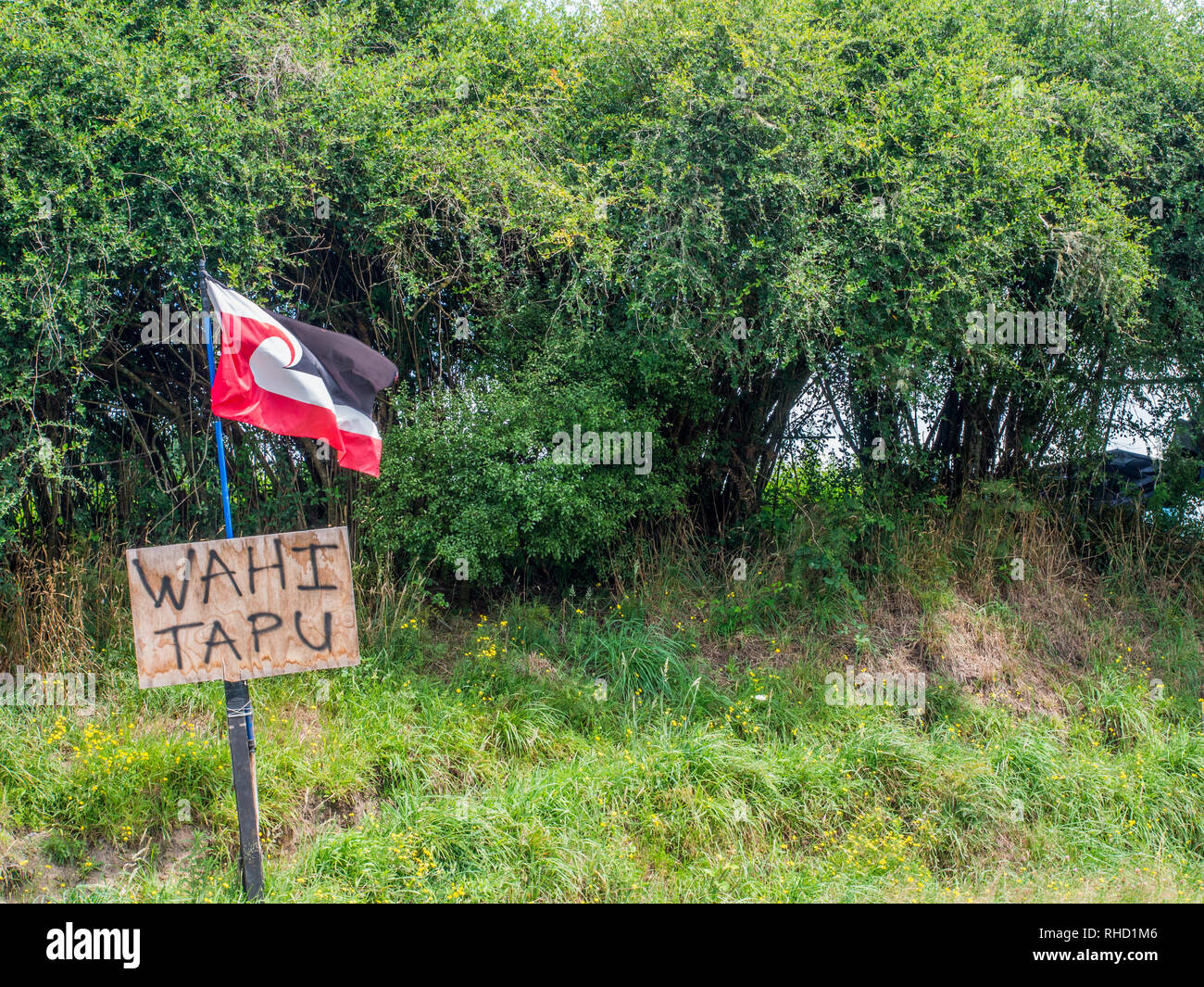 Tino Rangatiratanga Māori-Flagge und Tafel, die Website der wahi Tapu heiliger Ort, unrechtmäßig jetzt ein Bauernhof, in der Nähe von Murapara, Bay of Plenty, Neuseeland Stockfoto