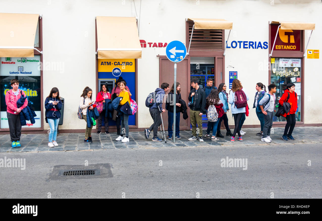 Jugendliche nach der Schule warten auf einen Bus in Sevilla, Spanien Stockfoto