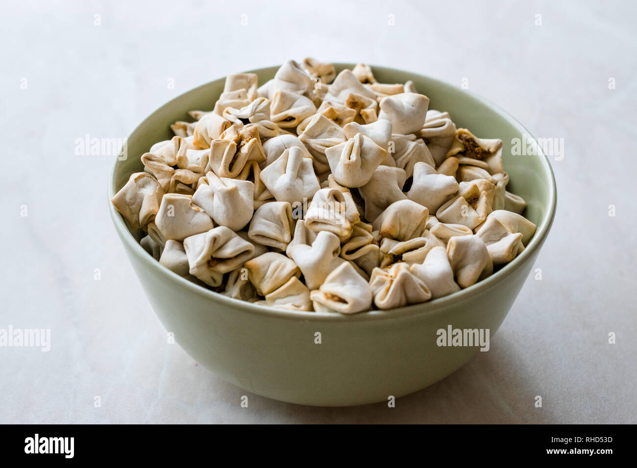 Hausgemachte knusprige Manlama Raw manti (Türkische Ravioli) in der Schüssel. Traditionelle Instant Essen. Stockfoto