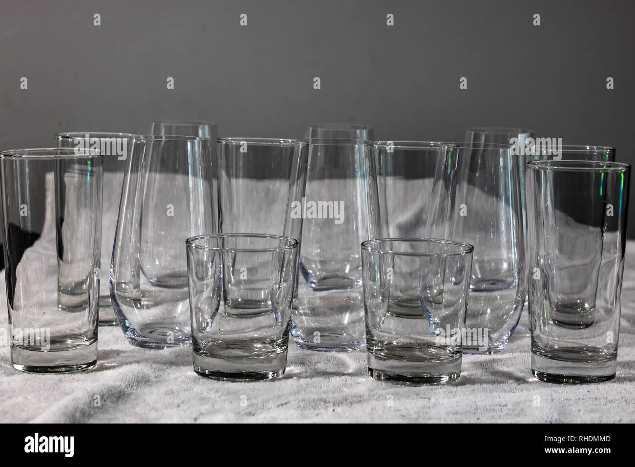 Interessantes Muster von Glas Trinkgläser, groß, klein, stemless, auf ein weißes Handtuch. Stockfoto