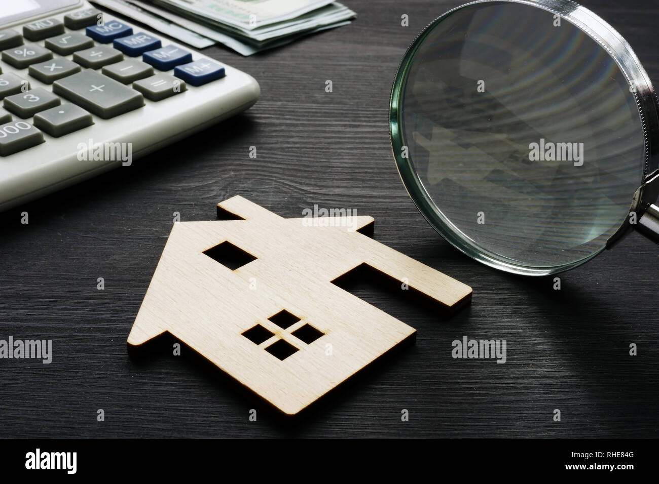 Immobilien Bewertung. Holzhaus mit Lupe und Rechner. Stockfoto