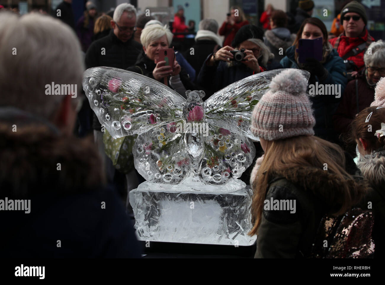 Mitglieder der öffentlichkeit mit einer eisskulptur eines Schmetterlings, Teil von York Eis Trail, in Yorkshire, nach Schneefällen gestern und über Nacht werden voraussichtlich weit verbreiteten Störungen zu bringen. Stockfoto