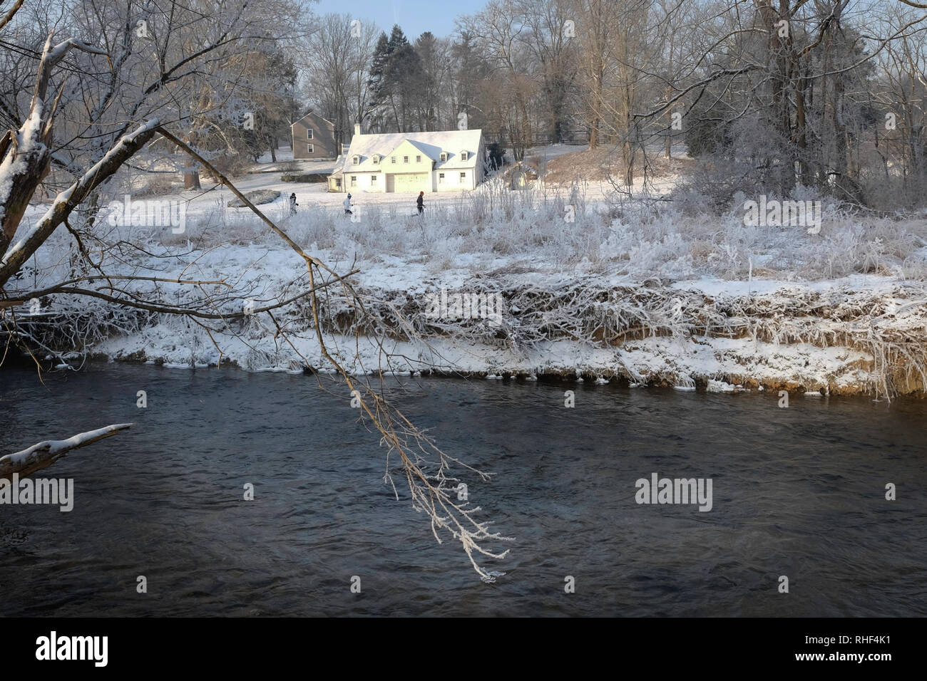 Chesterbrook PA USA-02 02 2019: das Weiße Haus in der Sonne im Abstand mit Schnee bedeckt Gras und Bäume am Ufer des Flusses vor Stockfoto