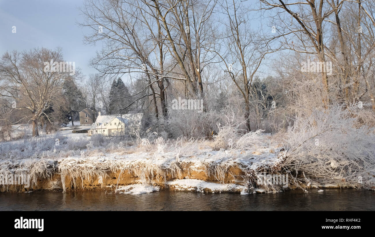 Chesterbrook PA USA-02 02 2019: das Weiße Haus in der Sonne im Abstand mit Schnee bedeckt Gras und Bäume am Ufer des Flusses vor Stockfoto