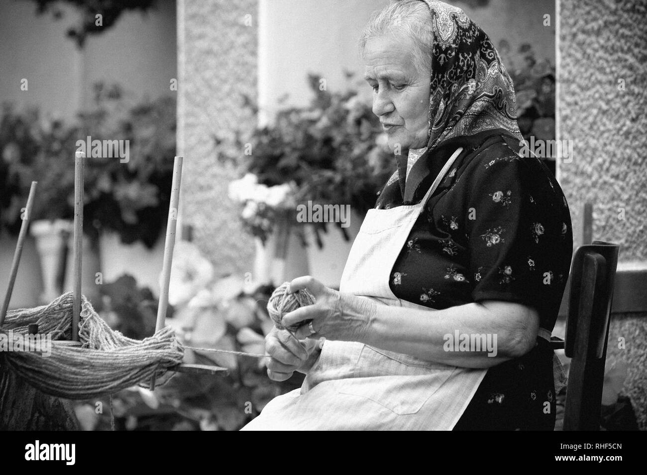 Porträt von einem rumänischen sehr alte Frau in traditioneller Kleidung machen kniende Kugeln. Sehen Sie mehr Bilder. Stockfoto