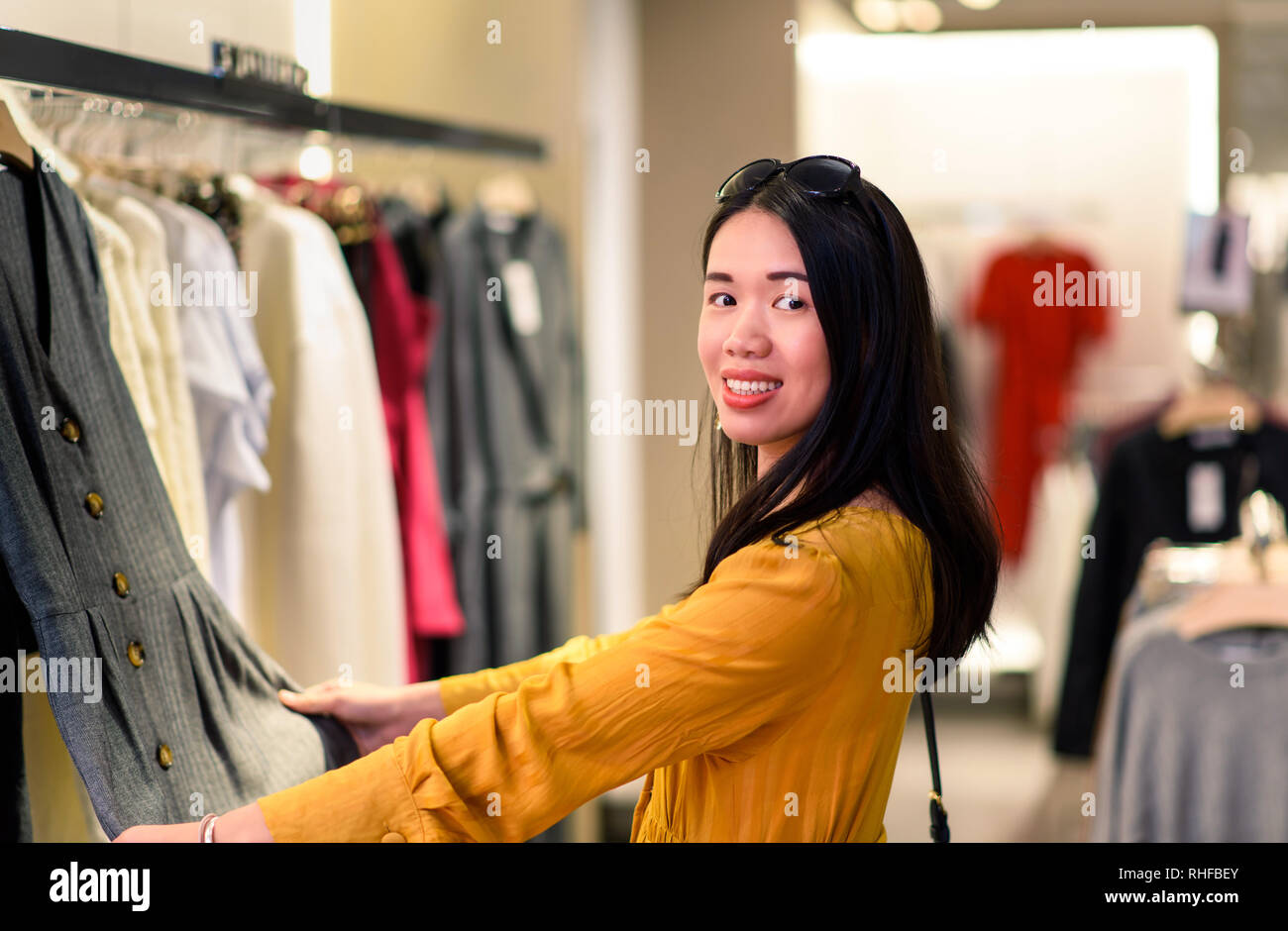 Mädchen versuchen, neue Kleidung in der Boutique Stockfoto
