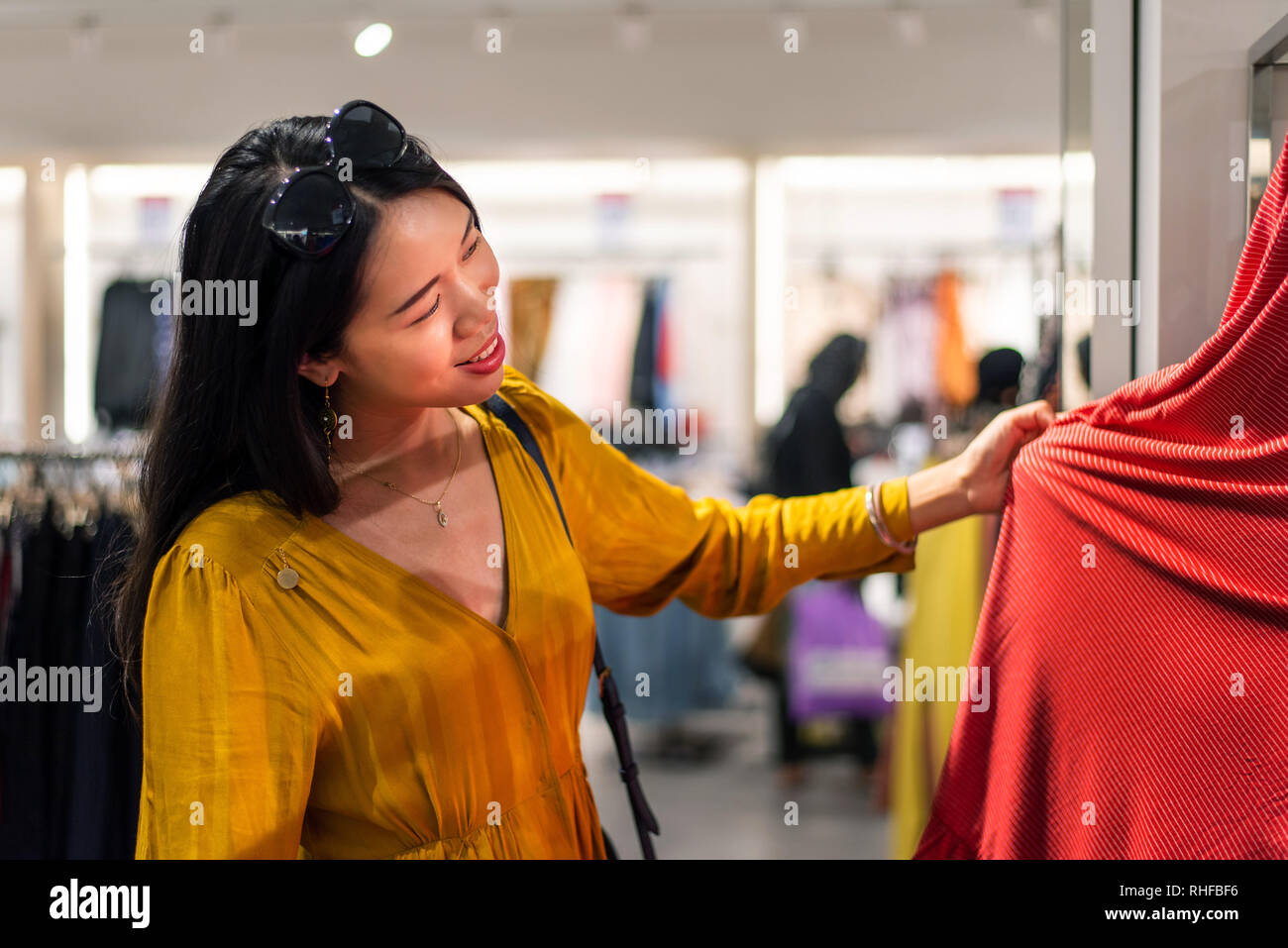 Mädchen versuchen, neue Kleidung in der Boutique Stockfoto