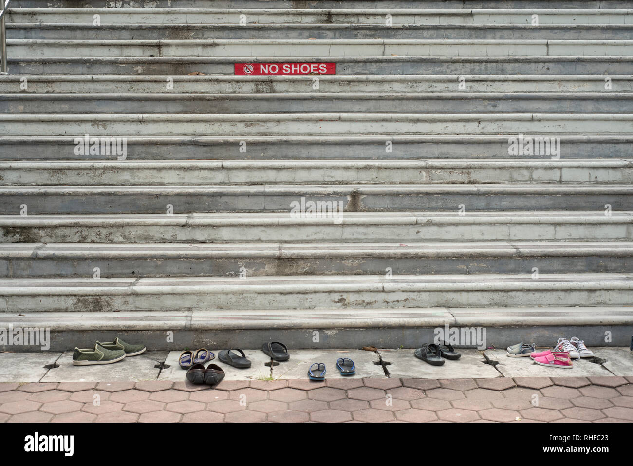 Schritte einer steinernen Treppe zu einem Tempel mit einem roten Schild keine Schuhe und Schuhe vor der Treppe Stockfoto