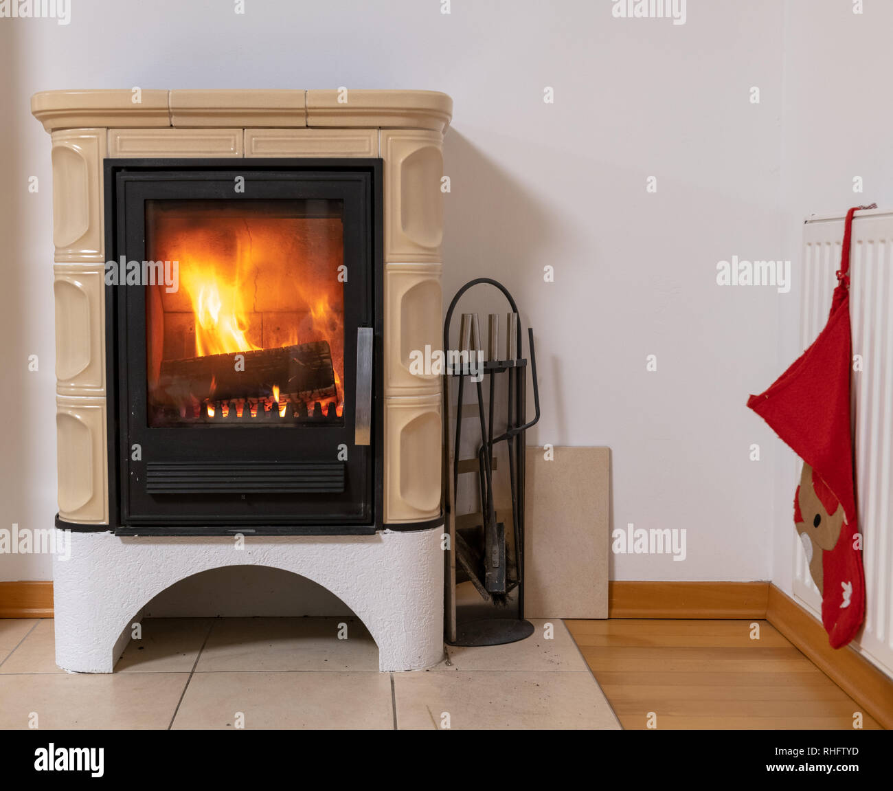 Kachelofen mit Feuer im Inneren, gemütlichen und warmen Innenraum Szene,  Heizung im Winter, Weihnachten Dekoration an der Wand Stockfotografie -  Alamy