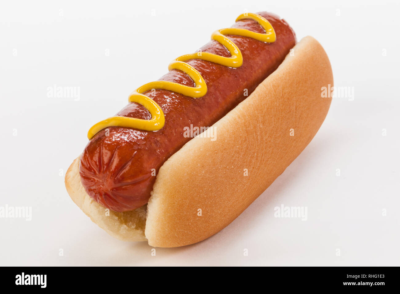 Riesen-Beefy-Hotdog auf einem Brötchen mit Senf auf weißem Hintergrund Stockfoto