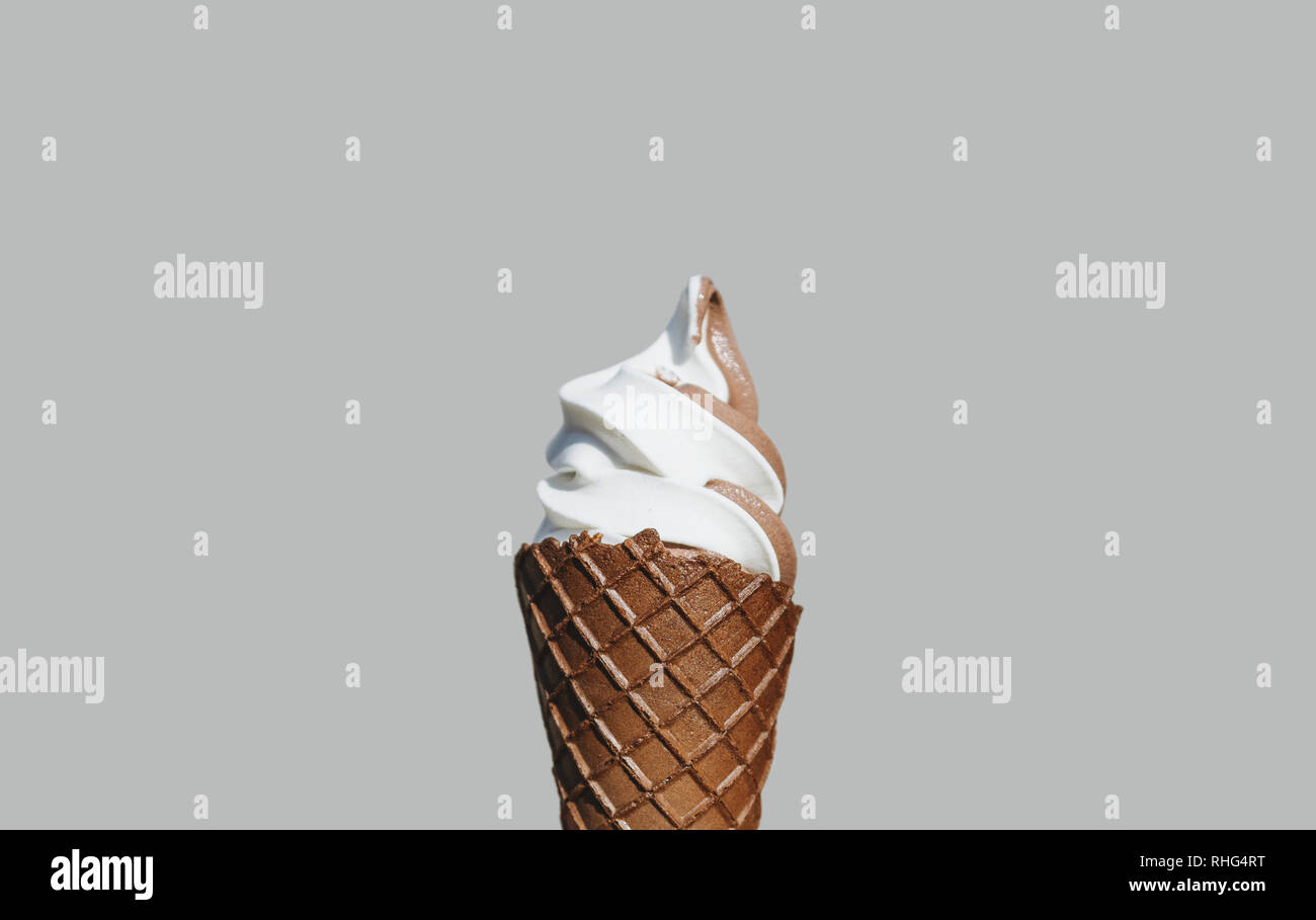 Weiche Creme Eis mit Schokolade Waffel Kegel, auf grauem Hintergrund Stockfoto