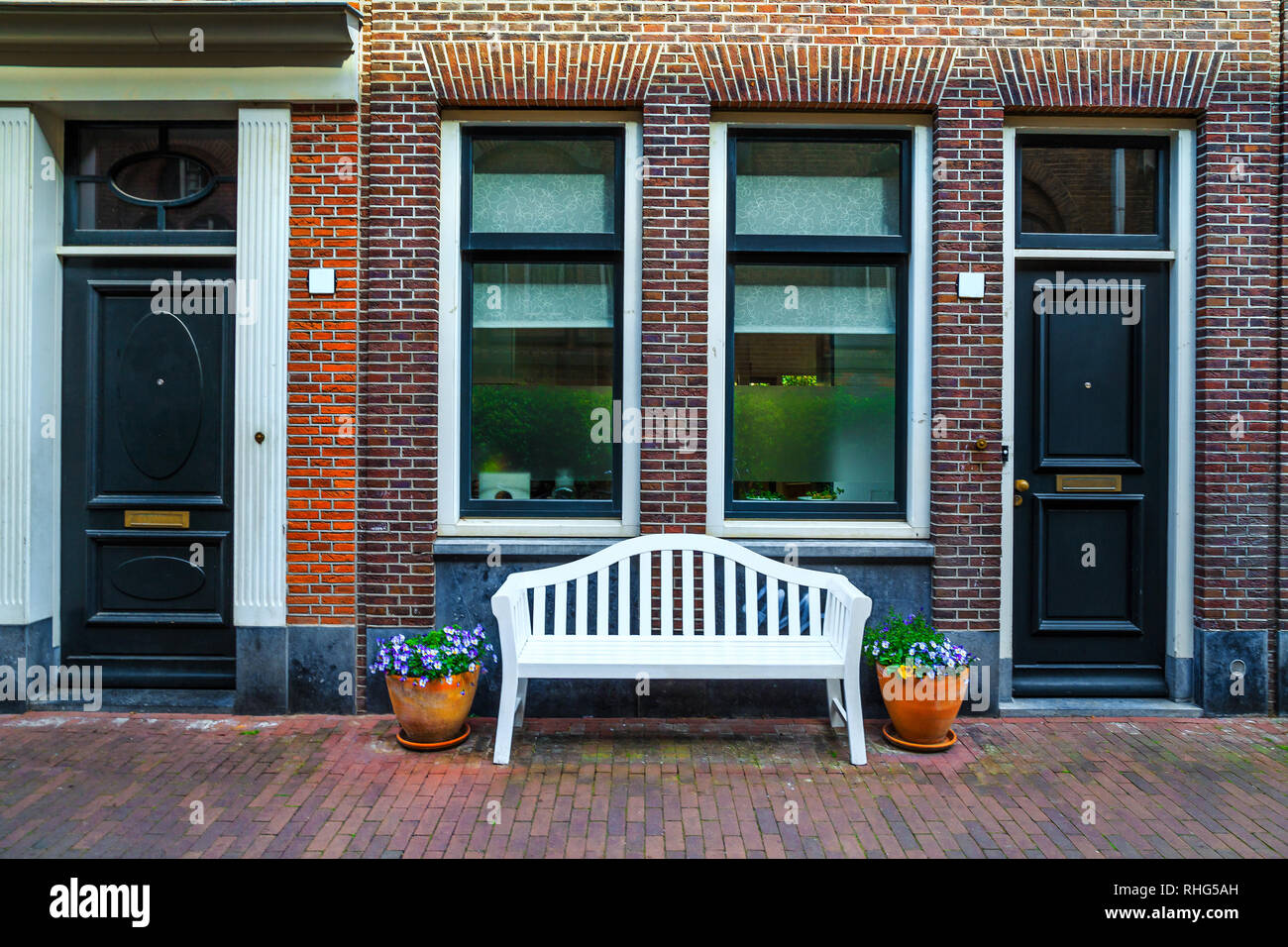 Wunderschöner Eingangsbereich und wunderschöne Backsteinhaus mit bunten Blumen, Amsterdam, Niederlande eingerichtet, Europa Stockfoto