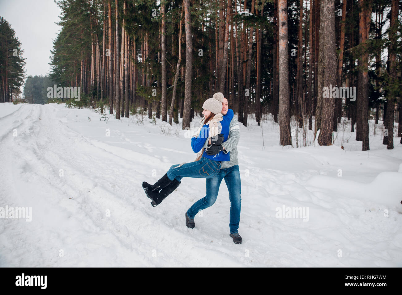 Liebevolle junges Paar, das Spaß im Winter Wald. Stockfoto