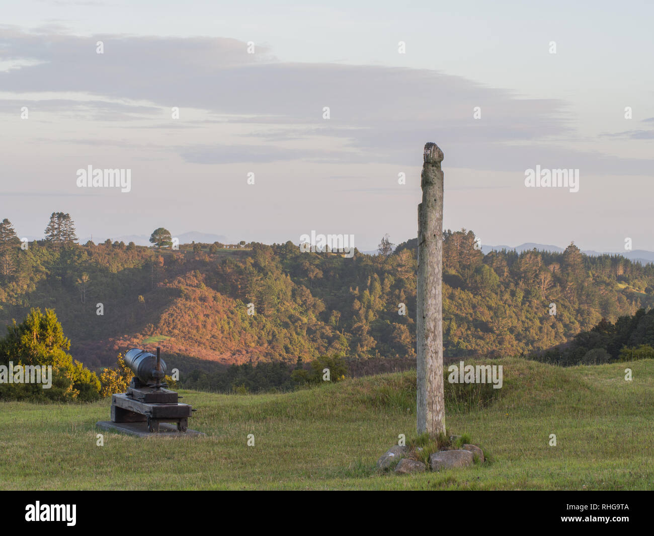 Poe whenua geschnitzten hölzernen Pfosten, und zerbrochene Kanone, Hügeln und Mulden Überreste der Befestigungsanlage Erdarbeiten, Ruapekpeka, Northland, Neuseeland Stockfoto