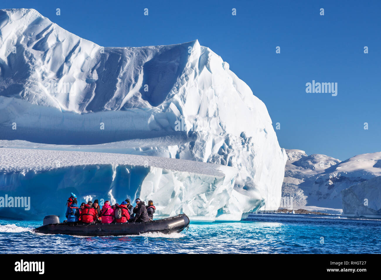 Touristen sitzen auf Zodiac Boot, erkunden riesige Eisberge in der ...