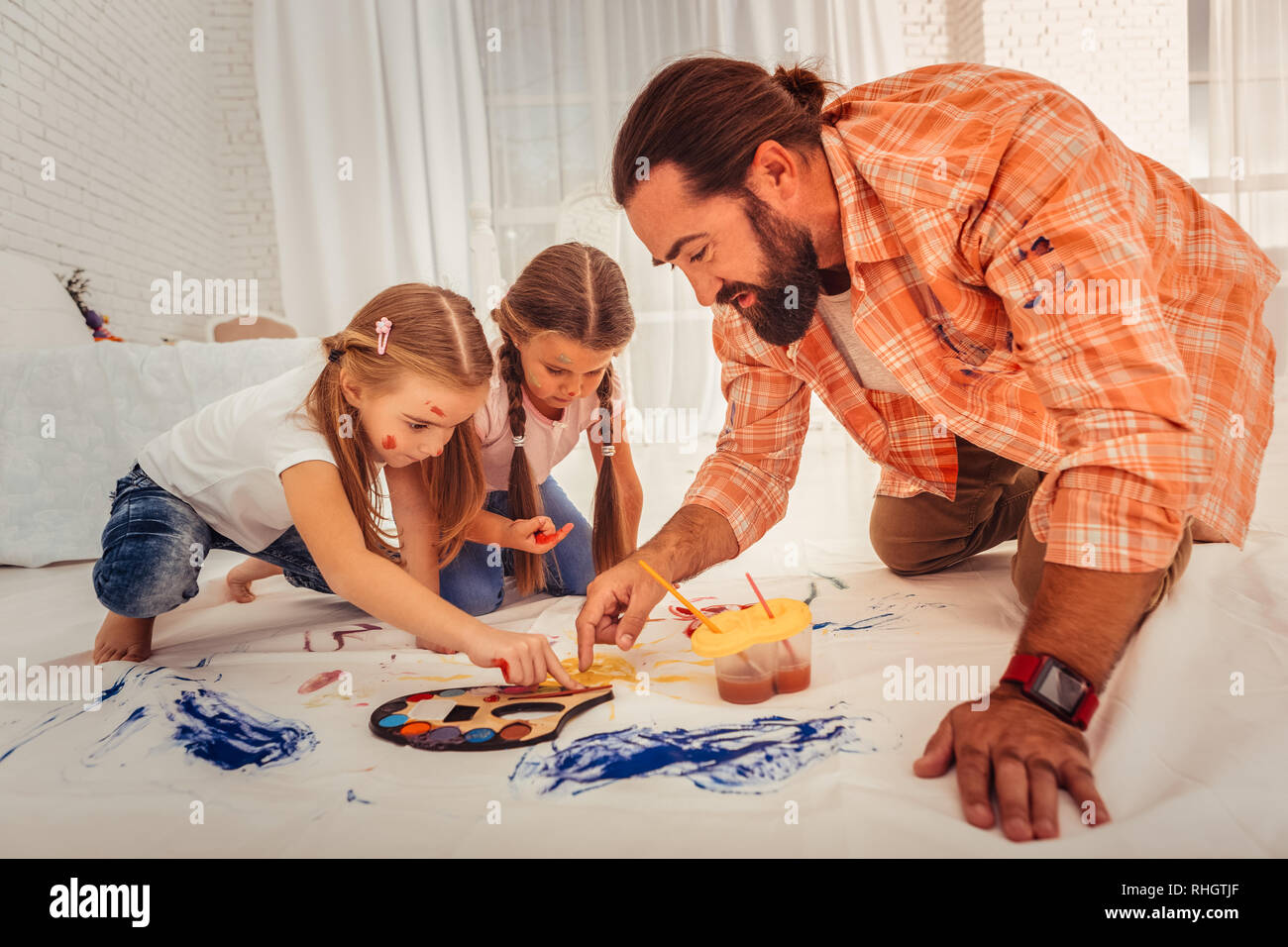 Schöne bärtige Mann lehre Mädchen auf Stoff malen Stockfoto