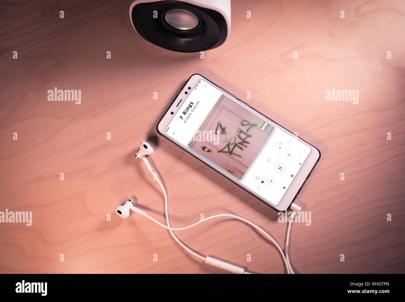 Ansicht von oben Bild von Smartphone, Ohrhörer und Lautsprecher mit Ariana Grande Song auf dem Bildschirm Stockfoto Ansicht von oben Bild von Smartphone, Ohrhörer und Lautsprecher mit Ariana Grande Song auf dem Bildschirm Stockfoto
