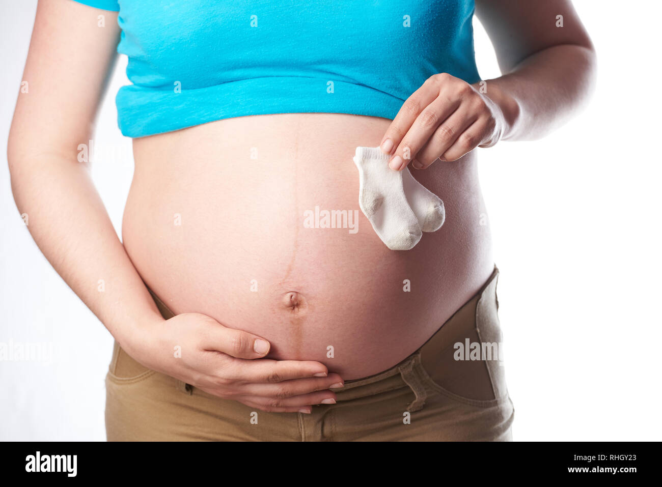 In der Nähe von schwangeren Bauch mit Hand Baby Socken Stockfoto