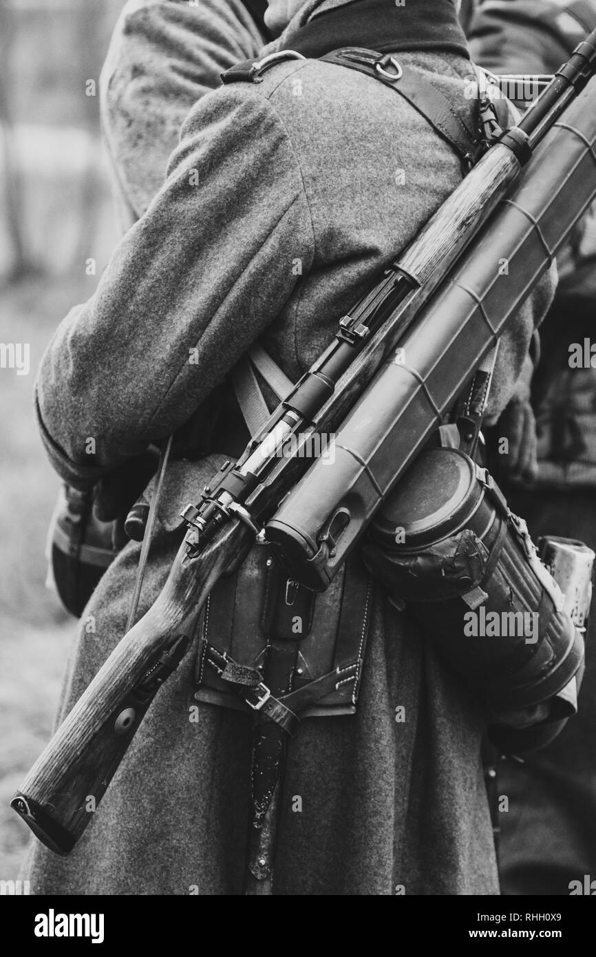 Wehrmachtssoldaten in ihre Mäntel mit einem Gewehr auf dem Rücken, Uniformen der deutschen Soldaten im Zweiten Weltkrieg. Schwarz und Weiß Foto Stockfoto
