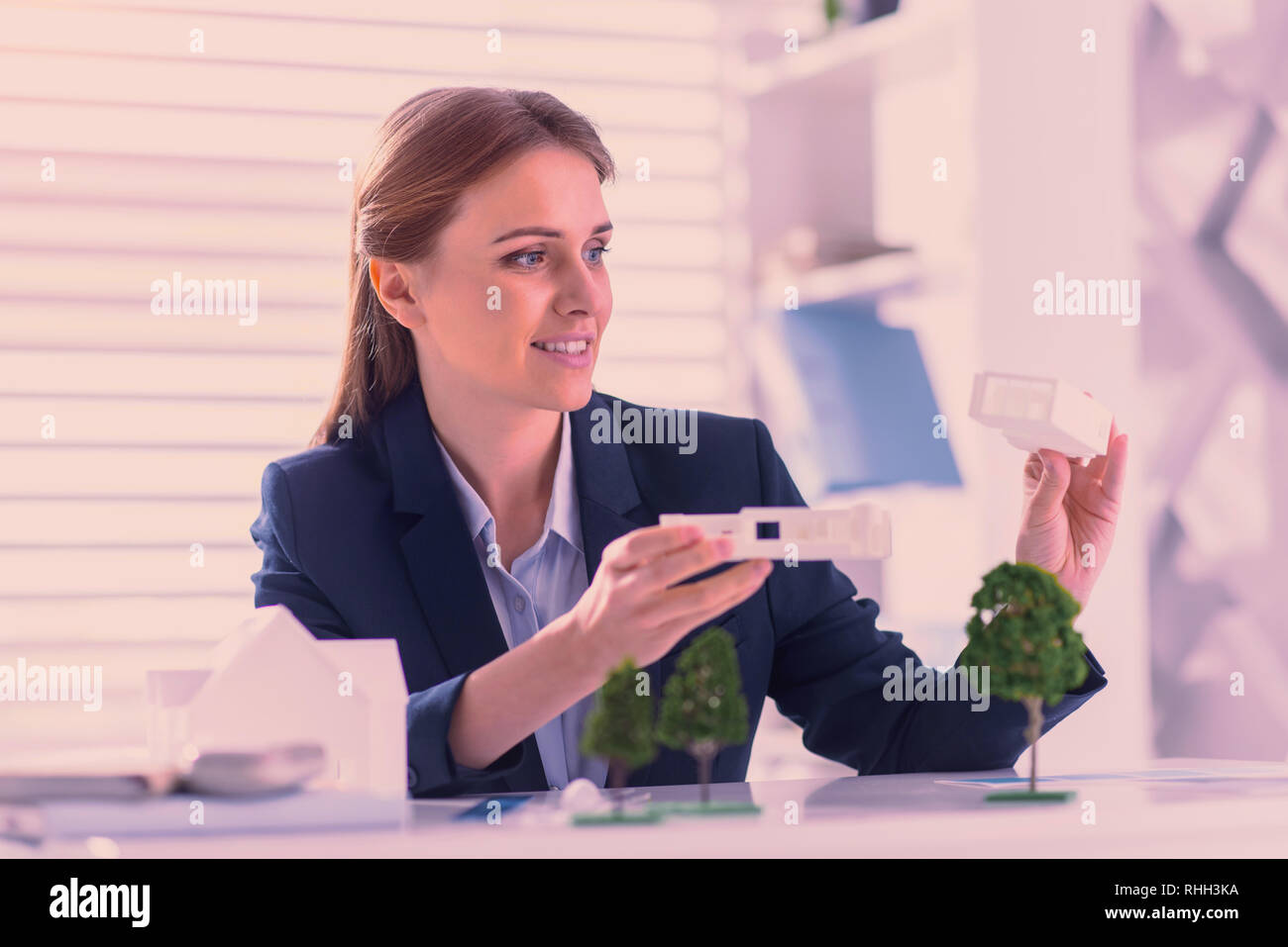 Meditative Ingenieurin Vergleich zweier Haus Modelle Stockfoto