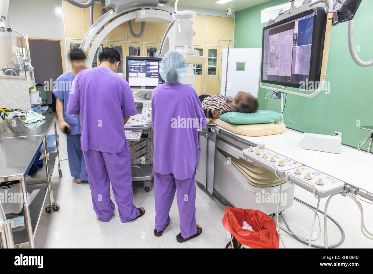 Der Arzt ist die Durchführung einer Patientenuntersuchung in der digitalen Subtraktionsangiographie Zimmer, DSA-Labor, Op mit X-ray medizinischen Scan. Stockfoto