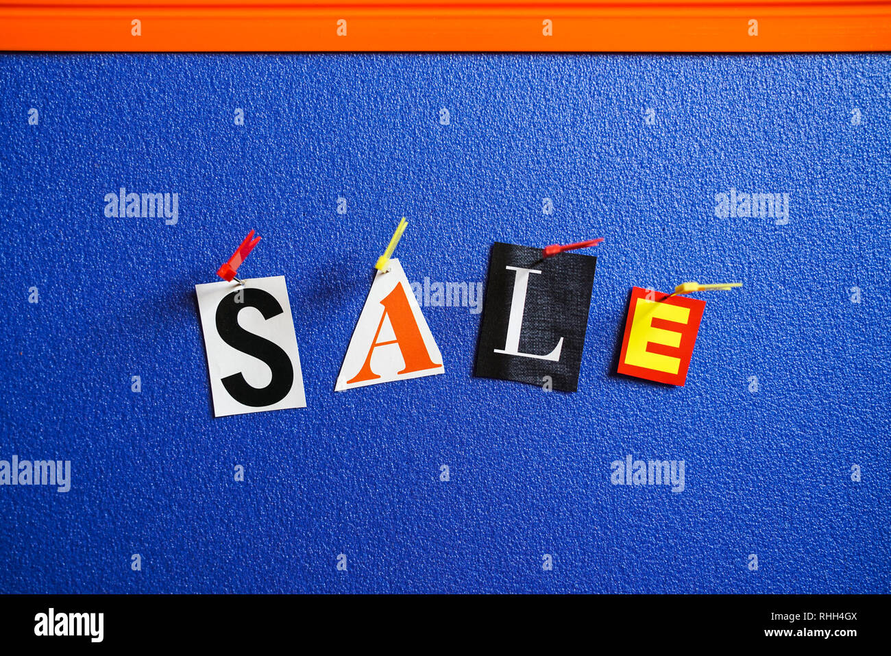 Verkauf Briefe von aus Magazin der verschiedenen Farben auf Blue Board festgesteckt Schnitt Stockfoto