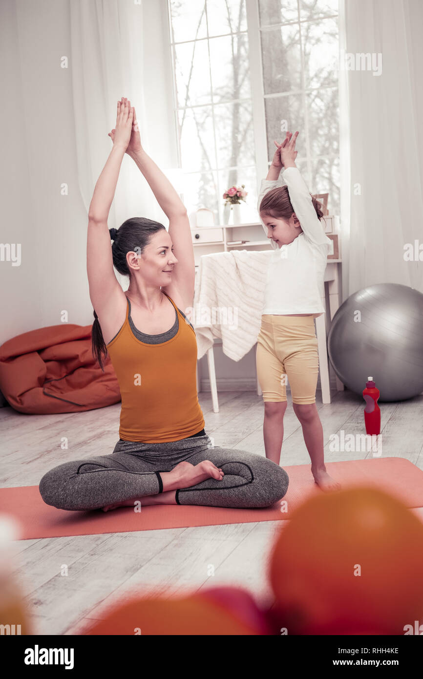 Die Mutter ihrer kleinen Tochter Yoga Posen Stockfoto