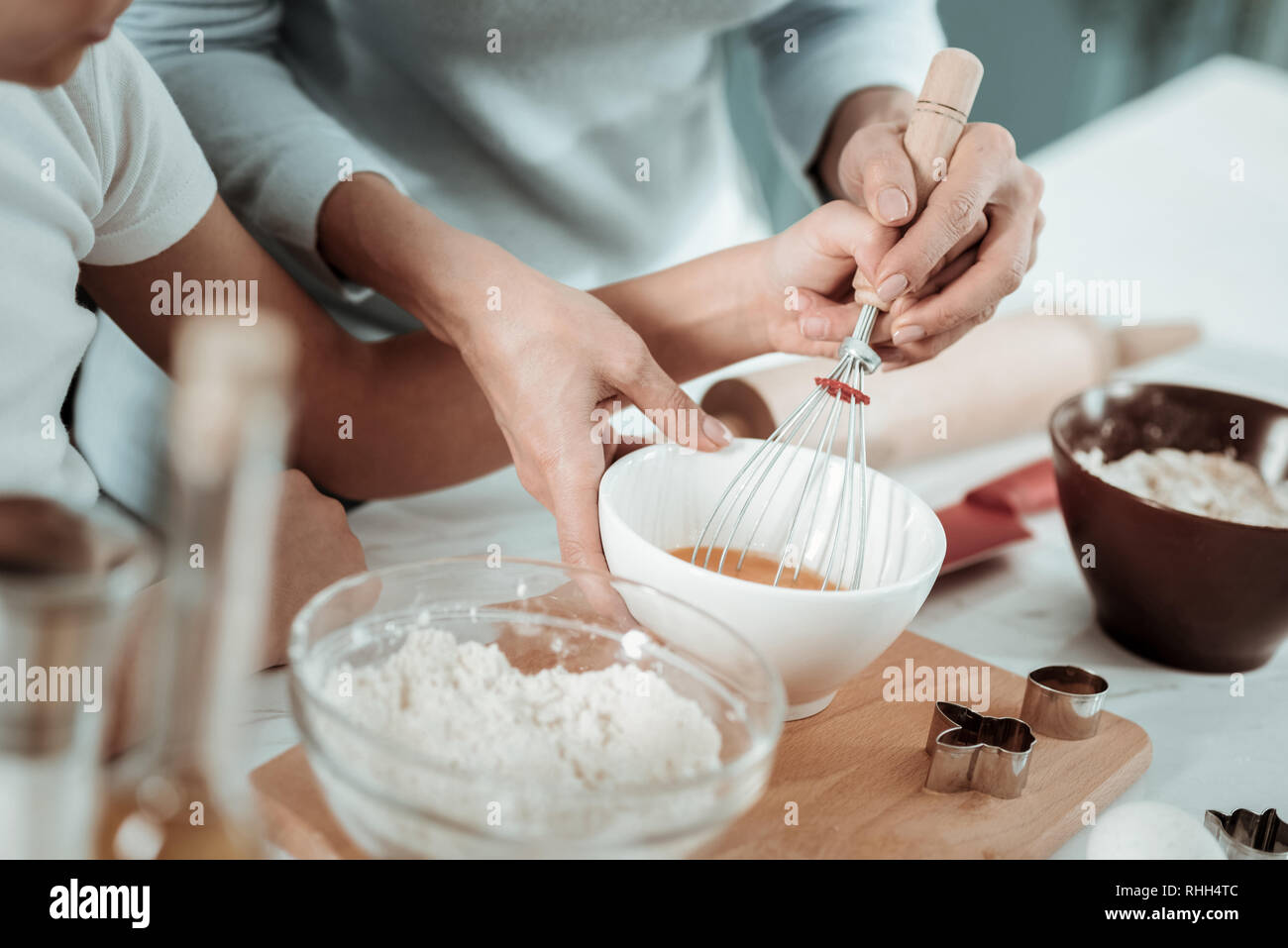 Aufmerksame Mutter Lehre ein Kind, wie man ein neues Gericht Stockfoto