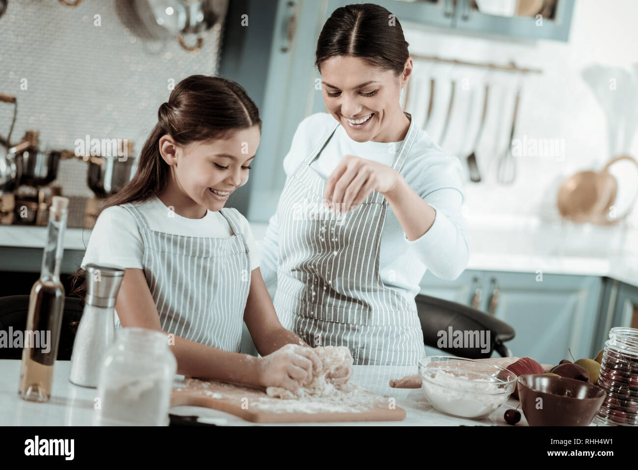 Glückliche Mutter und Tochter kochen ein leckeres Abendessen zusammen Stockfoto