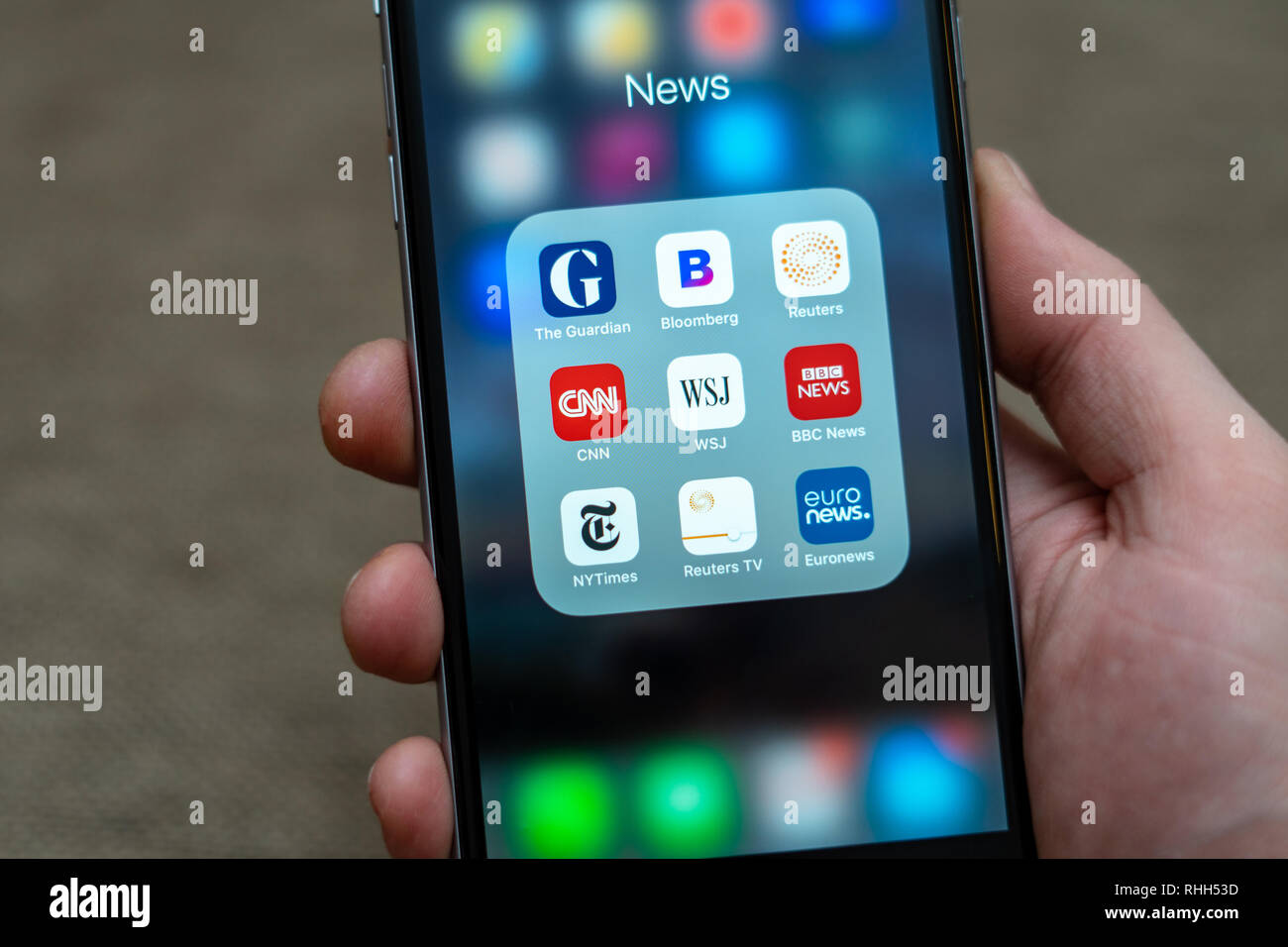 Männliche hand Schwarz Apple iPhone mit Symbolen der Medien: Guardian, Bloomberg, BBC News, CNN, NY Times, Euronews und andere Anwendung auf dem Bildschirm. Stockfoto