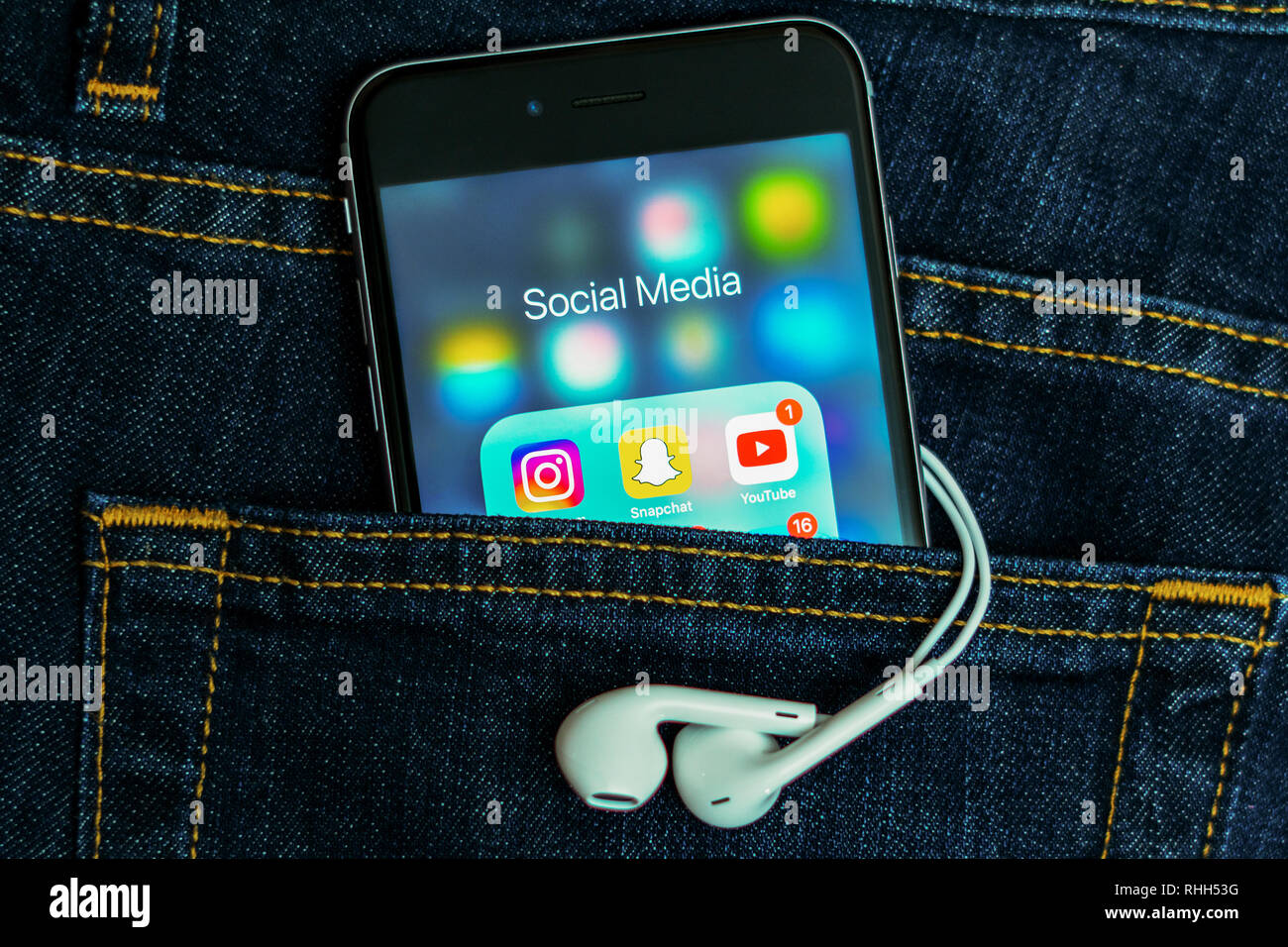 IPhone mit Symbolen der sozialen Medien: Instagram, Youtube, Studivz, Facebook, Twitter, snapchat auf dem Bildschirm. Social media Icons. Denim Jeans Hintergrund Stockfoto
